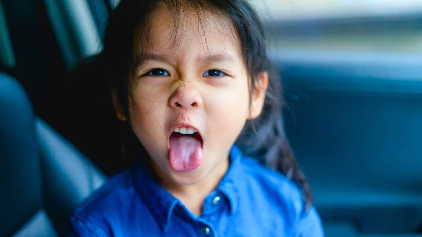 little girl without good manners sticking out her tongue