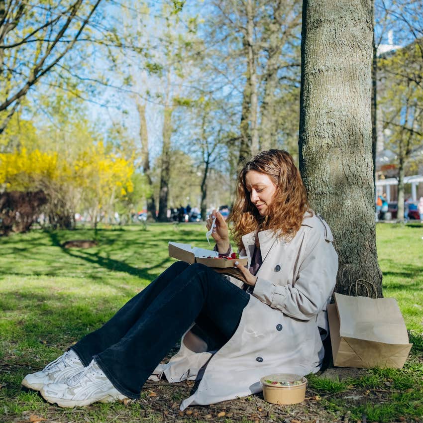 American worker eating her lunch alone in a park