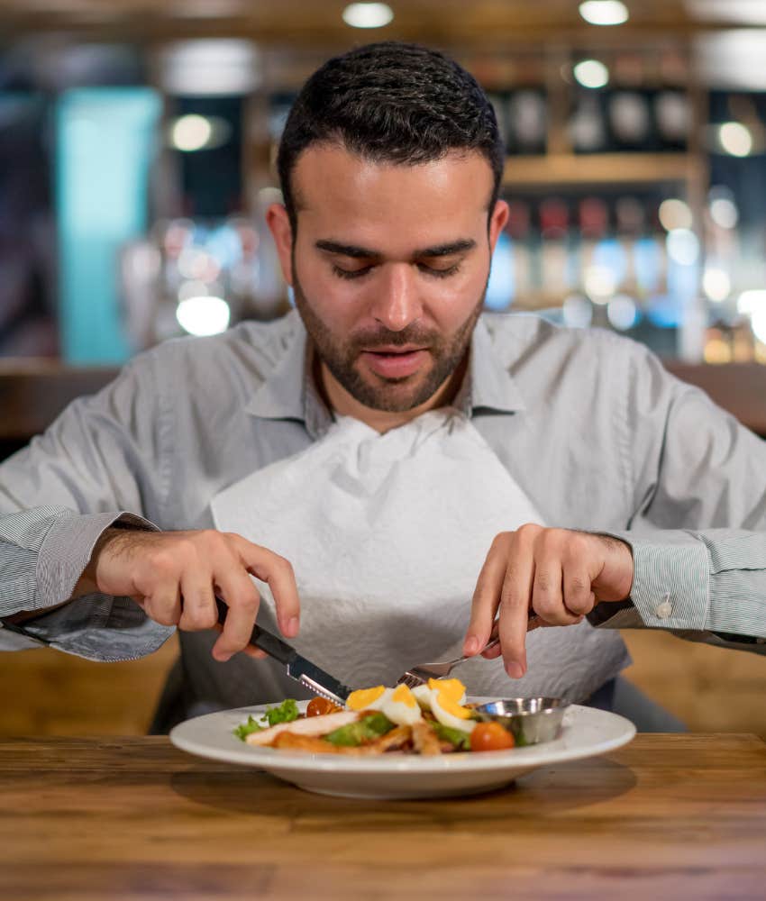 man eating with napkin tucked into shirt