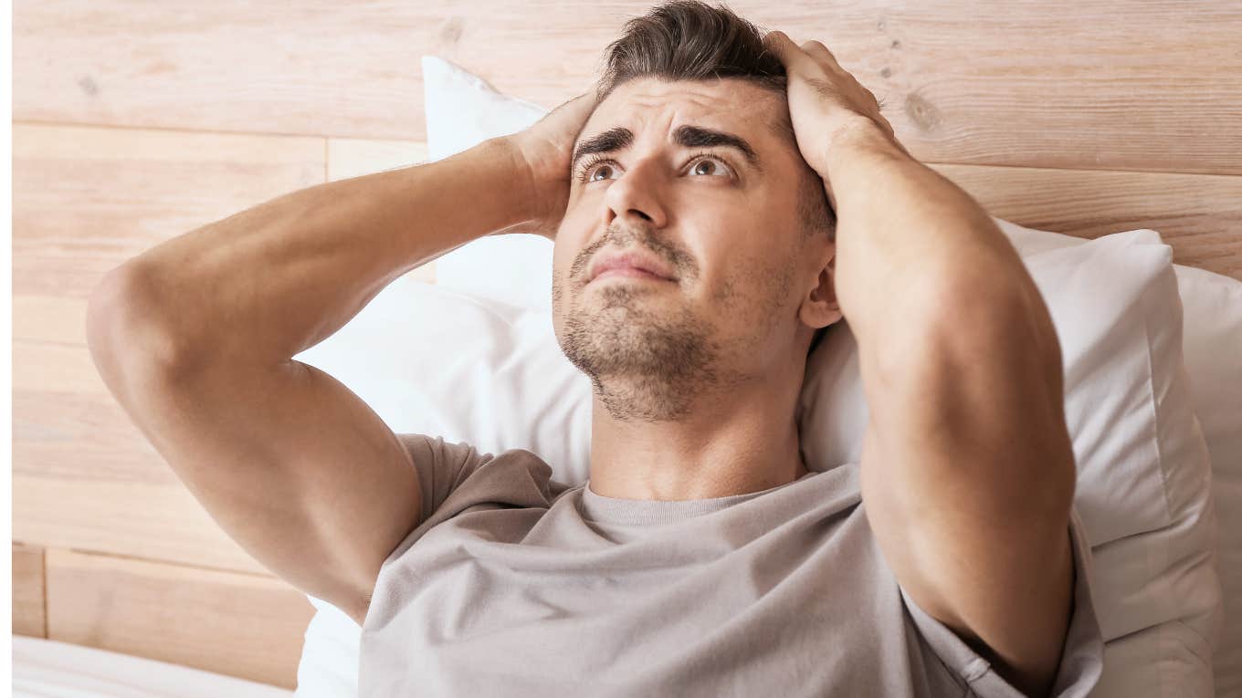 Man looking trapped sitting in his roommate's room. 