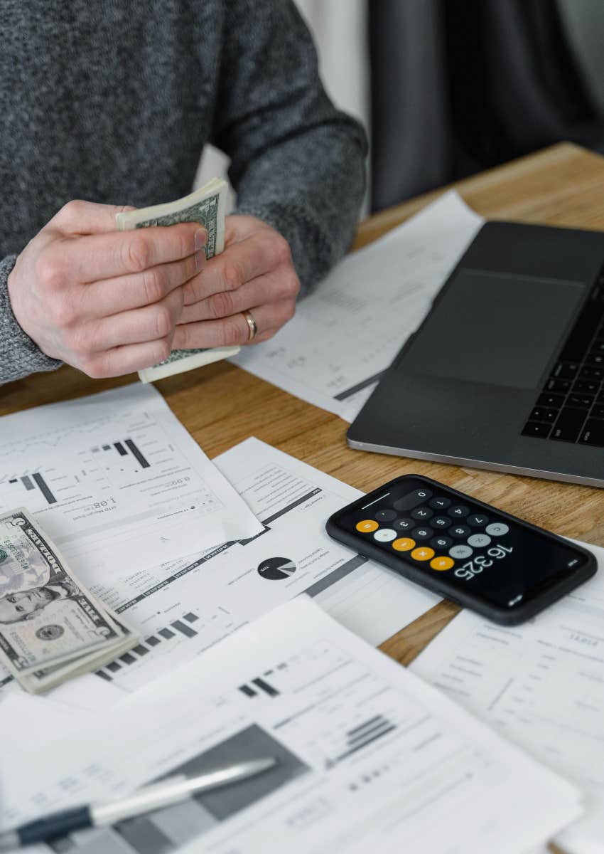 man counting money to pay bills on table