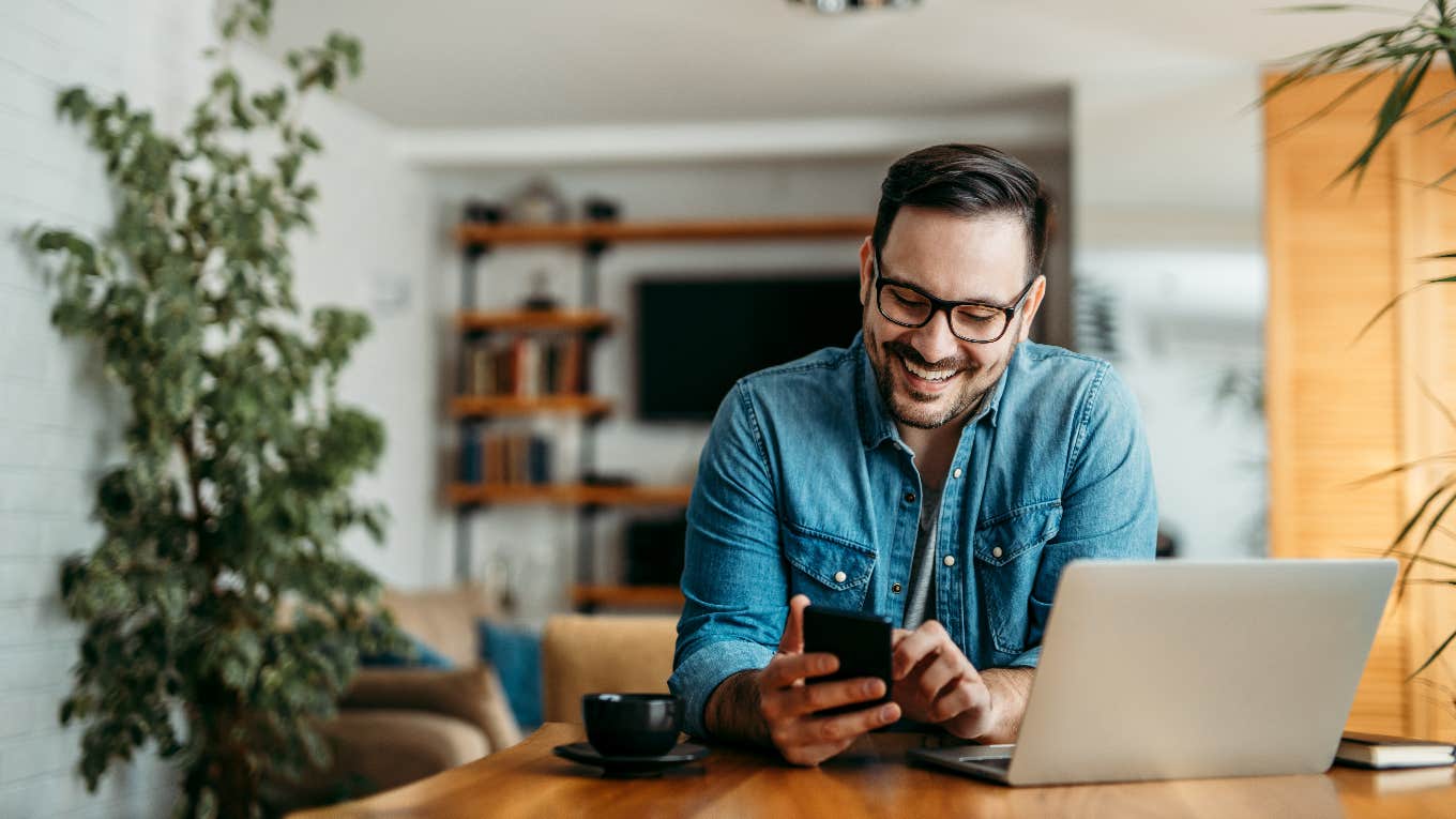 Happy man reading messages from former classmate