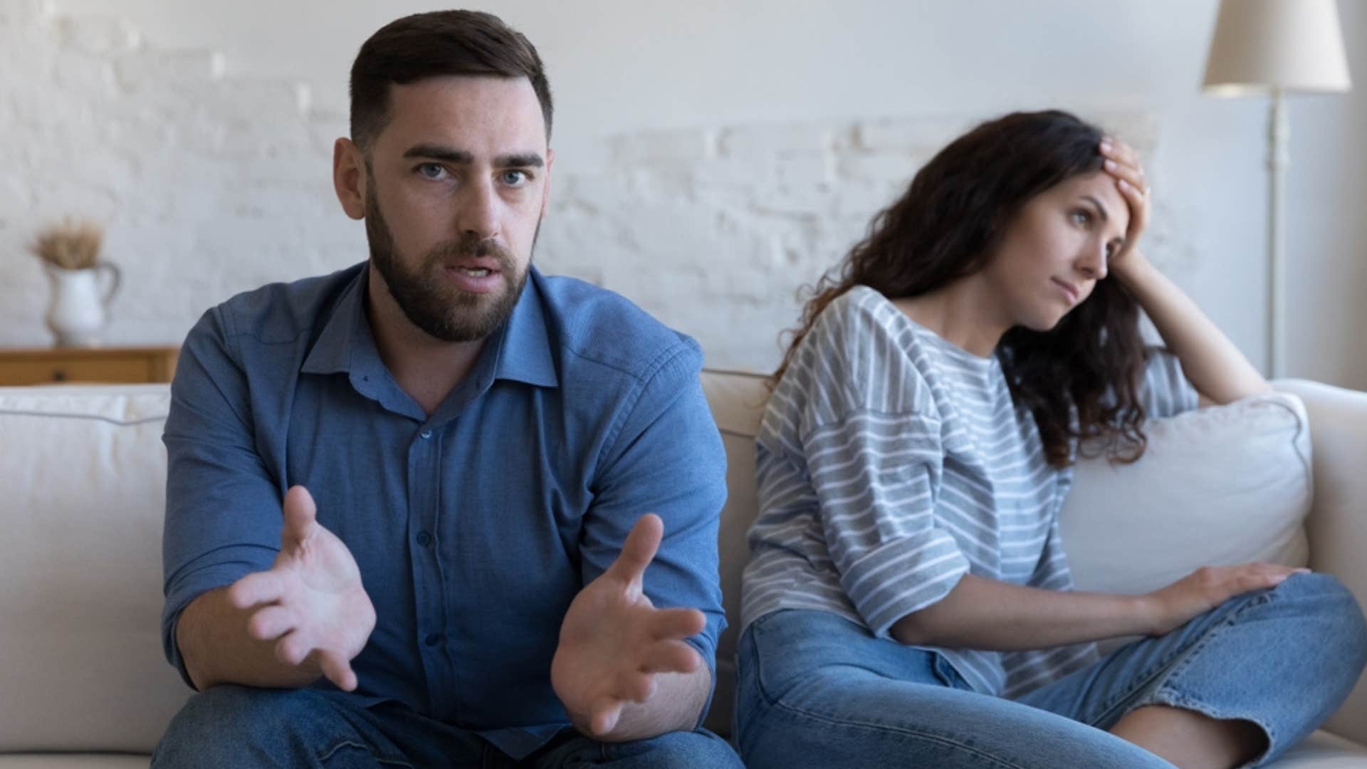 Man talking with his upset partner on the couch. 