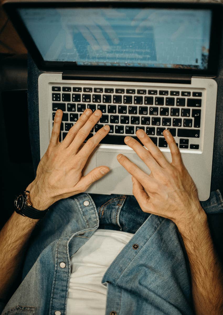 man typing on a laptop