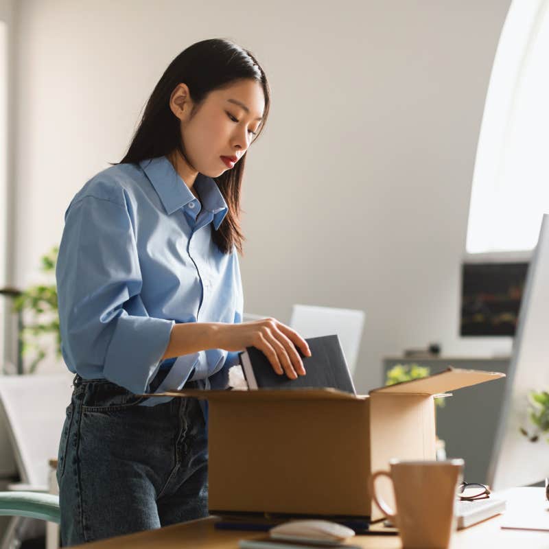 woman packing up things in box after being fired