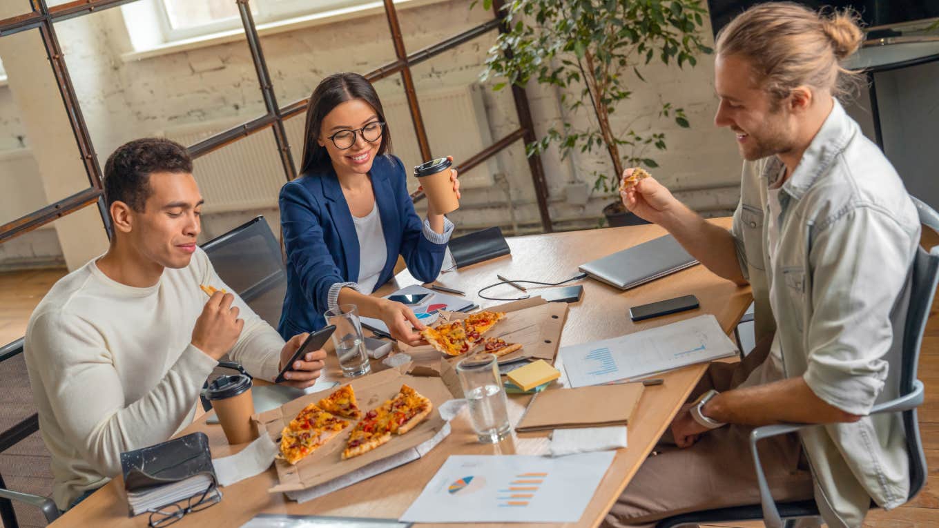 business team having break and eating pizza while being on job discussion in office boarding room.