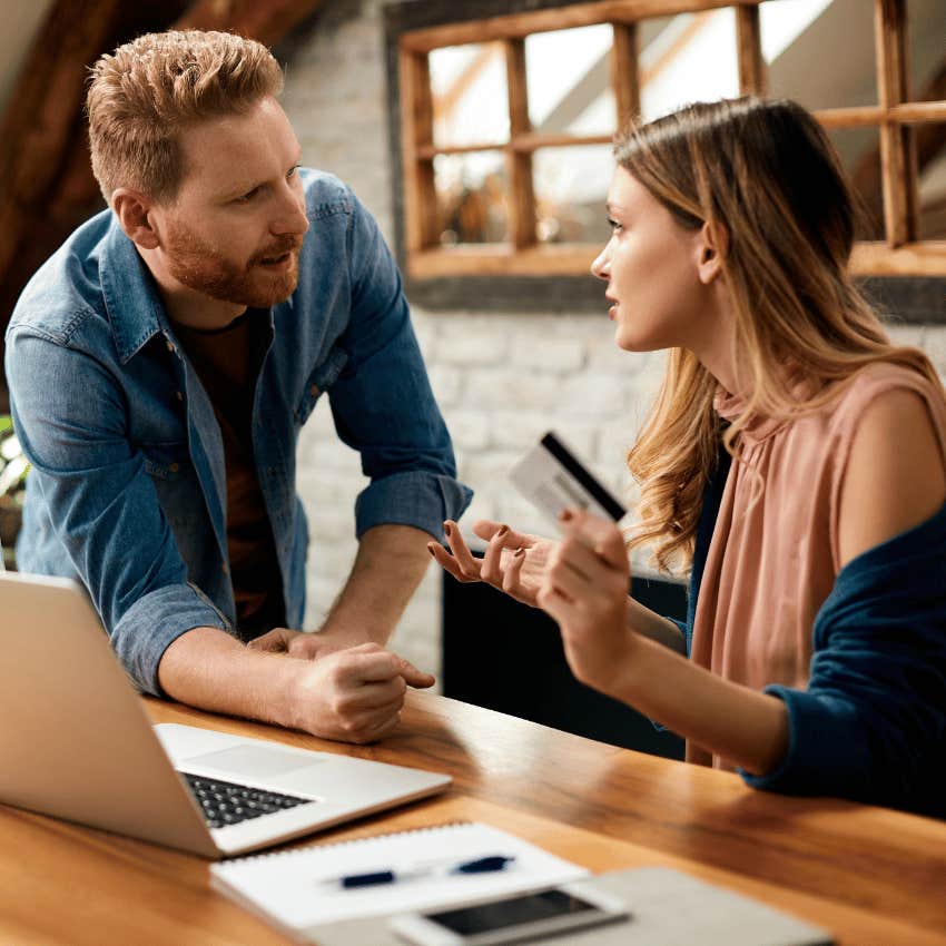 She holds credit card, he looks upset