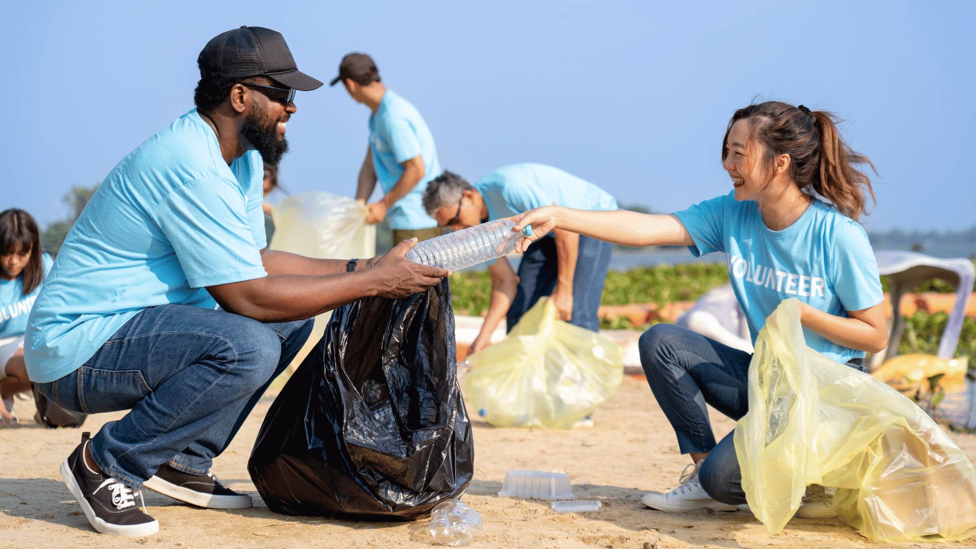 group of people cleaning up beach