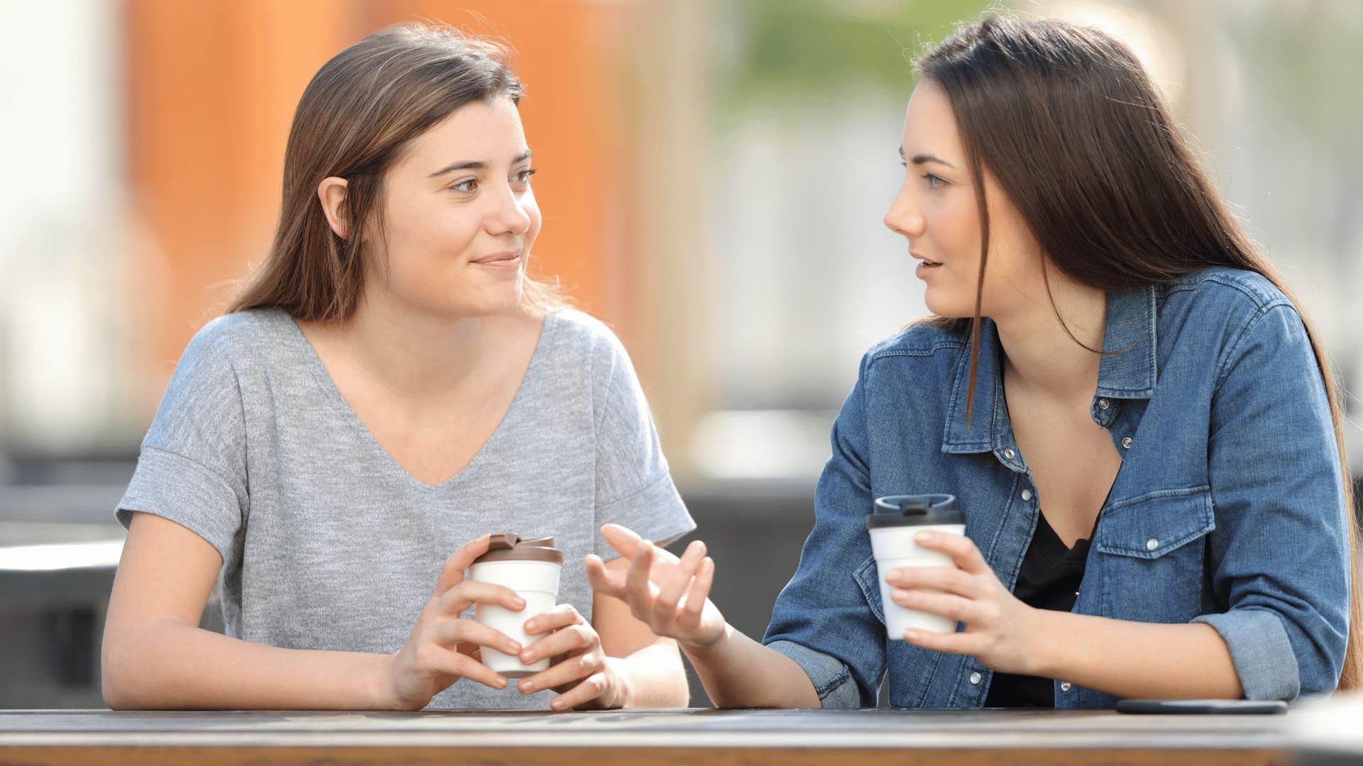 two friends chatting while drinking coffee