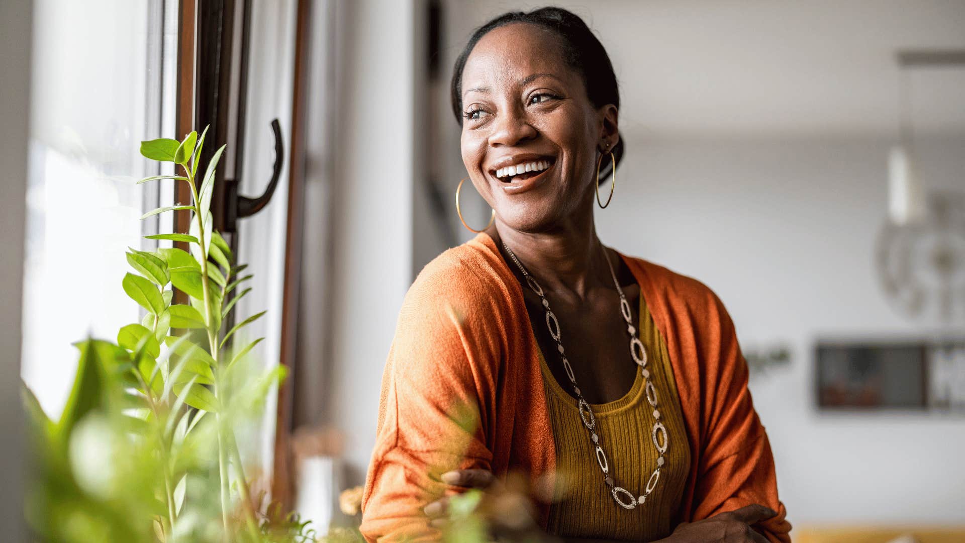 woman smiling while looking out of window