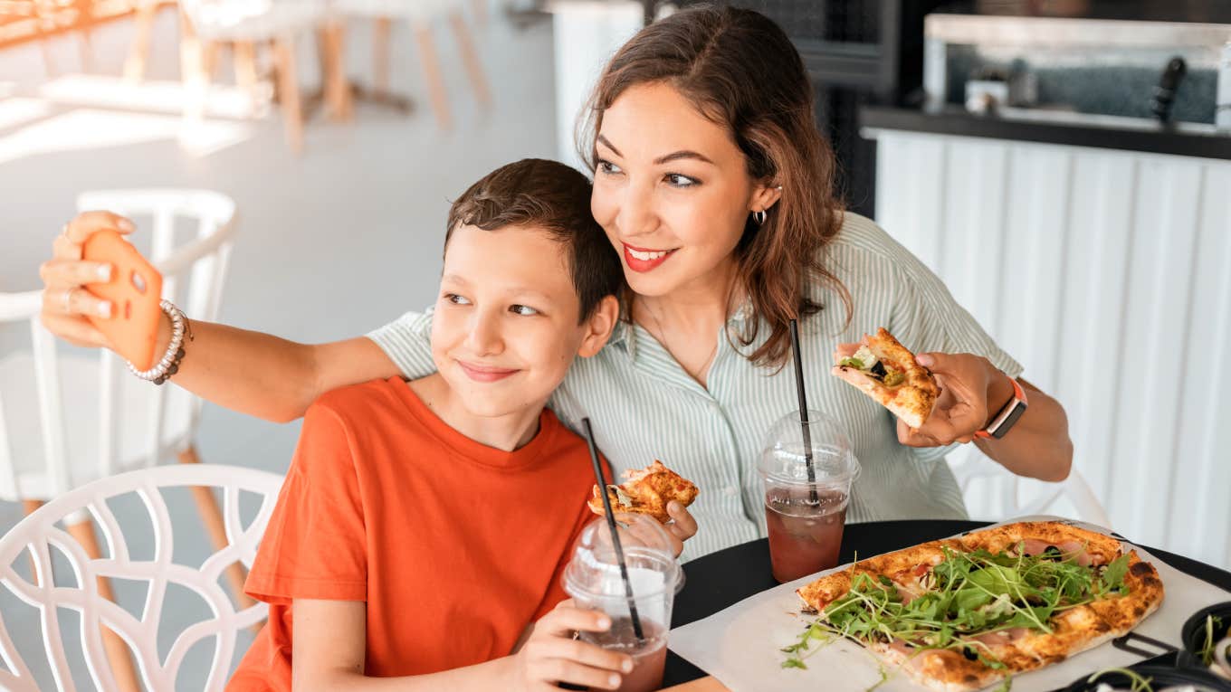 mom and son taking picture together eating at restaurant 