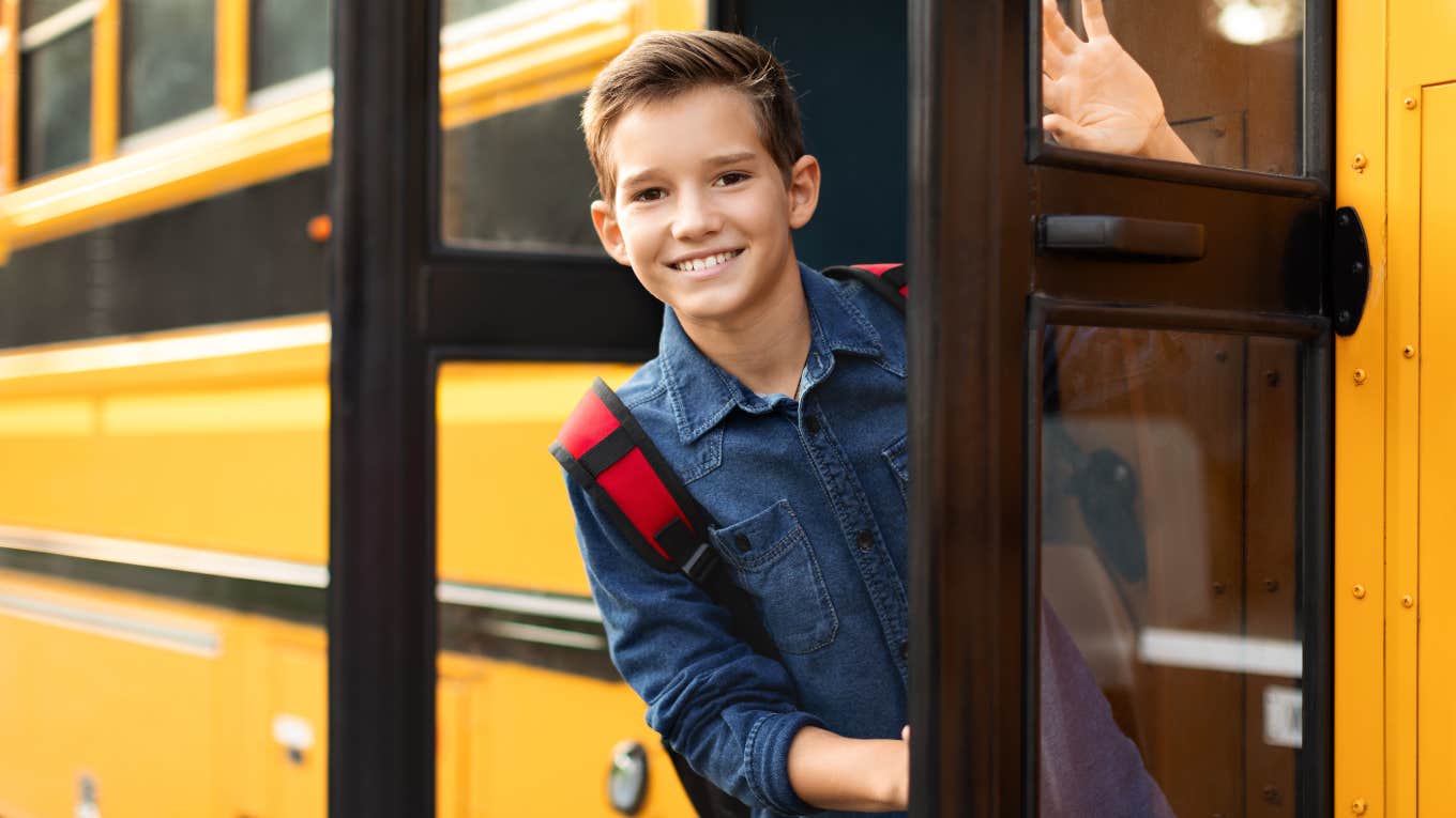 boy leaning out of school bus