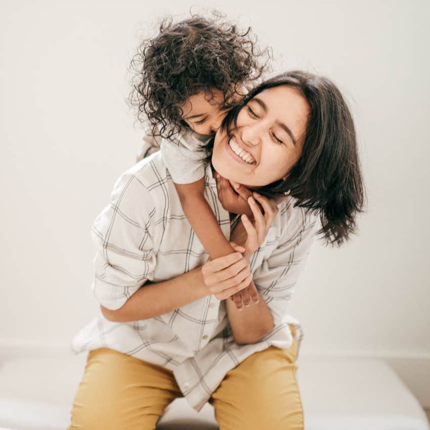 Divorced mom smiling and holding her toddler.