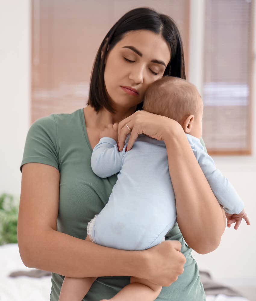 mom feeling desperate while hugging her baby