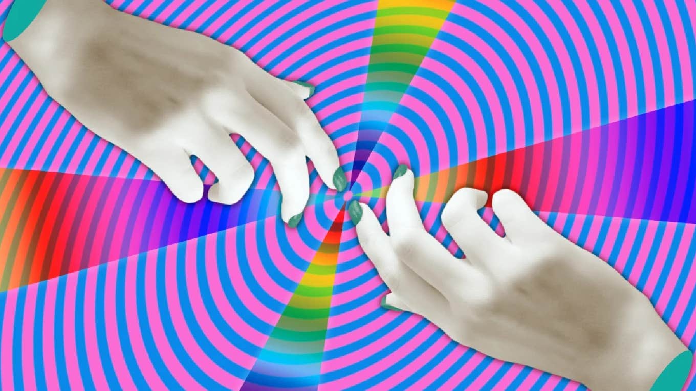 two hands nearly touching in front of swirling colors