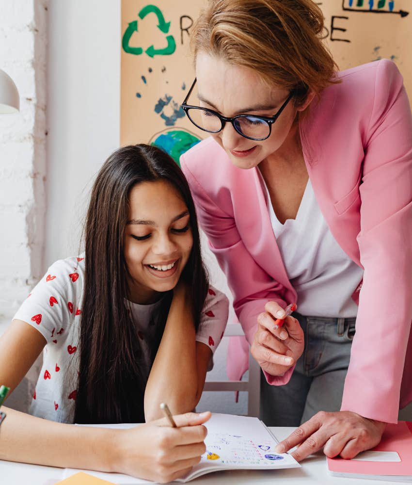 New teacher helping student in classroom