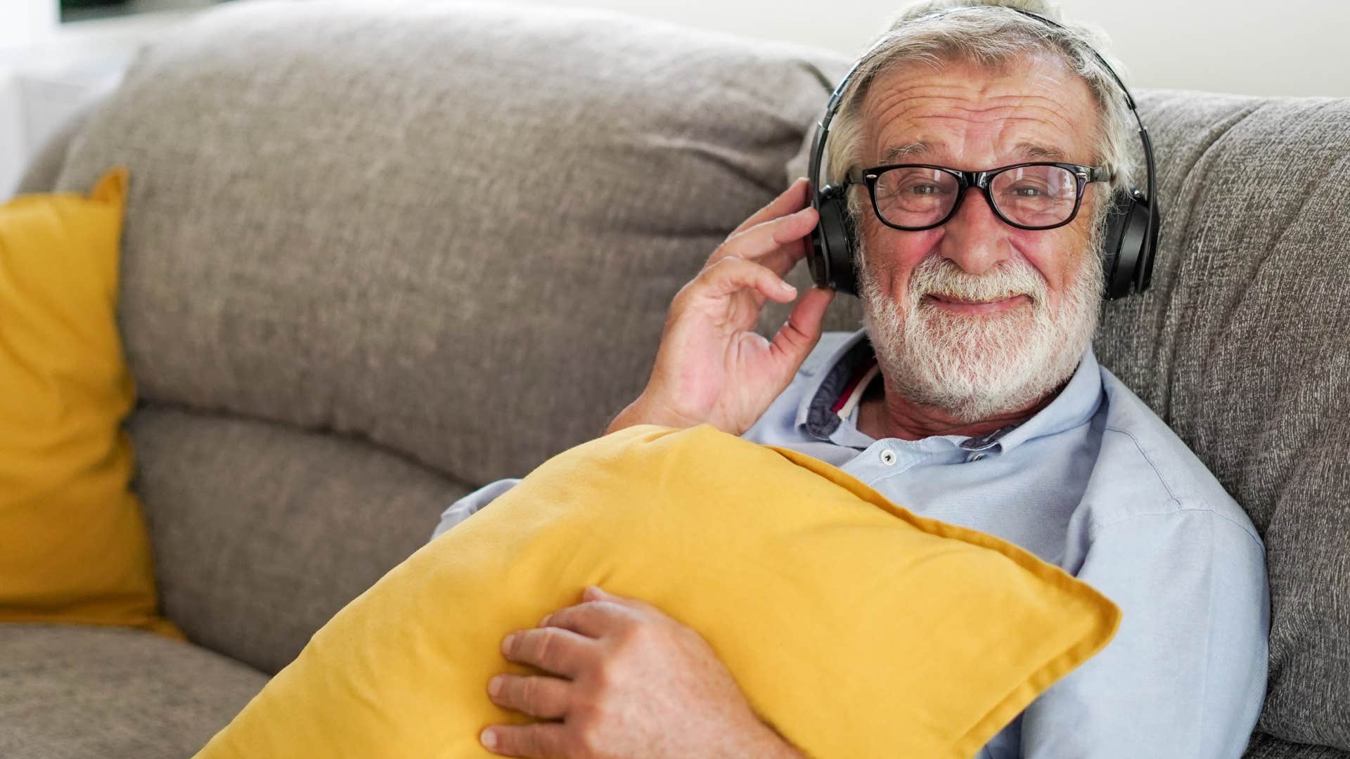 Old man listening to music happily. 