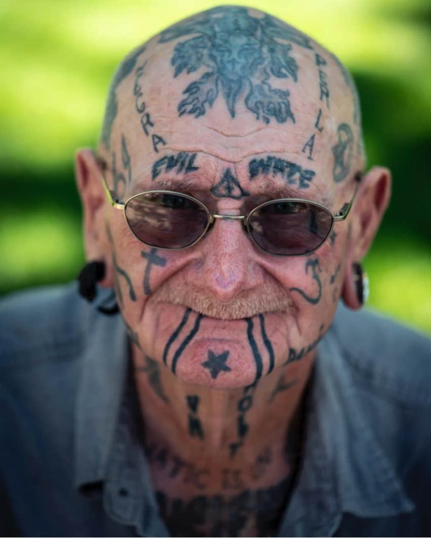 old man with tattooed head and face