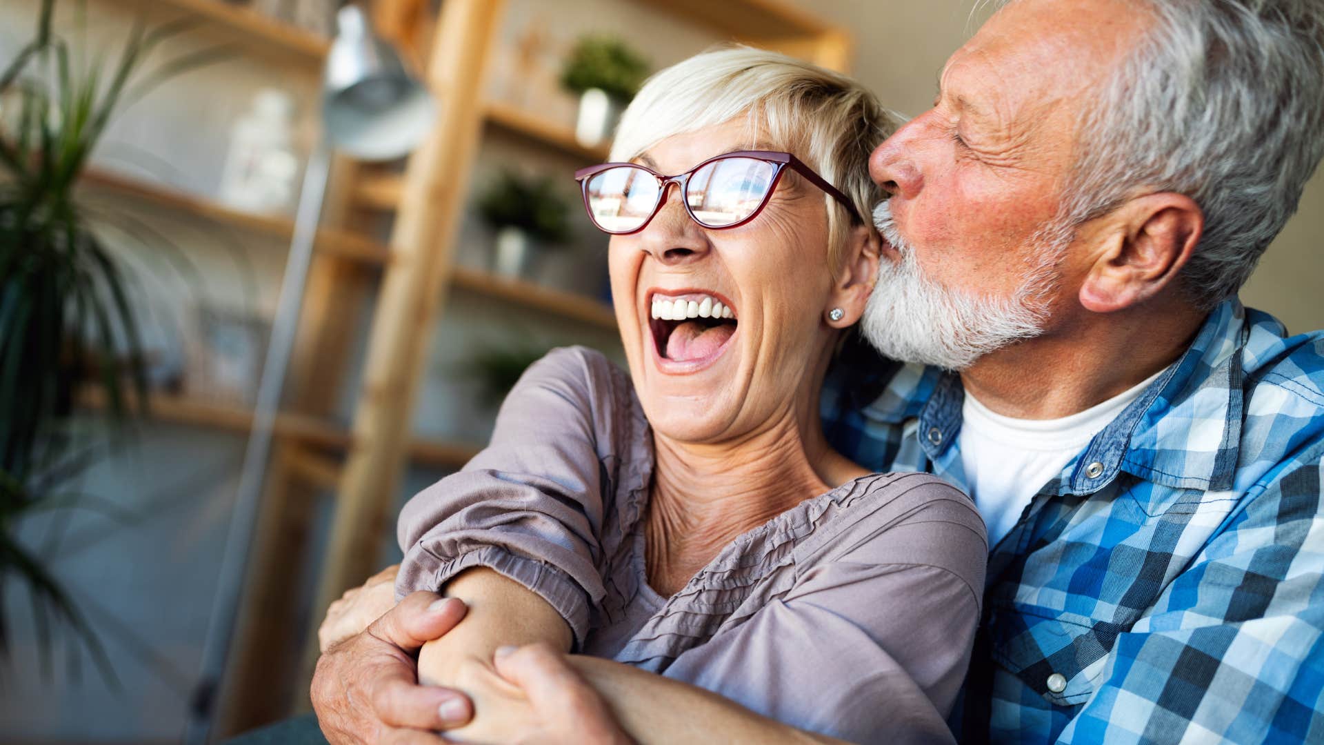 Older couple smiling and hugging. 