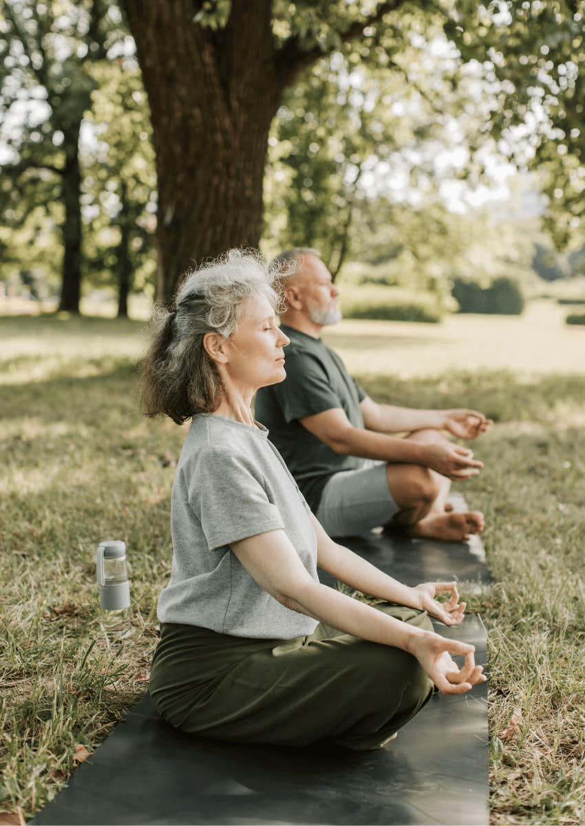 older couple meditating outdoors