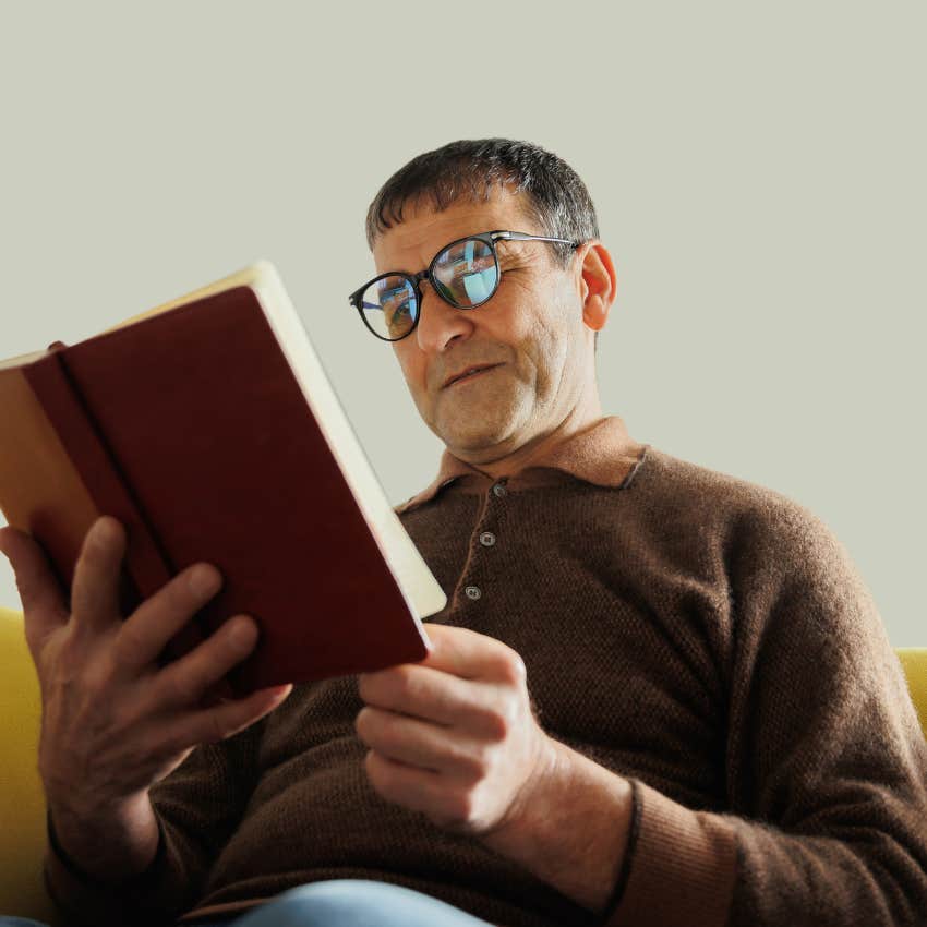 Older professor looking at an appreciative message in a book. 