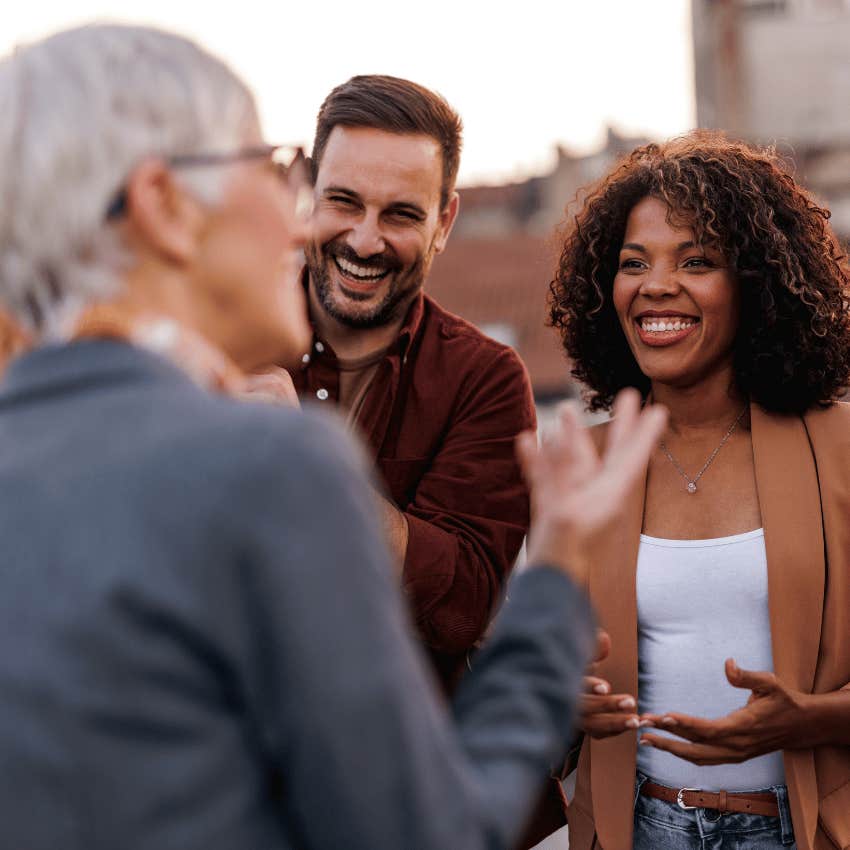 older woman making young business people laugh