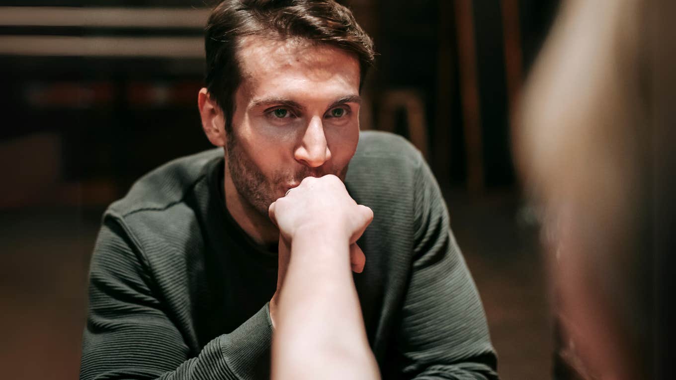 Ominous man kissing woman's hand on date. 