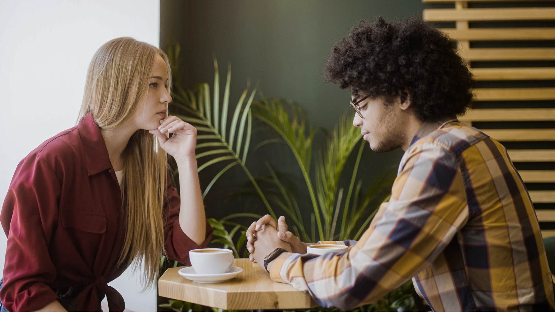 Couple looking tense while talking in a coffee shop.