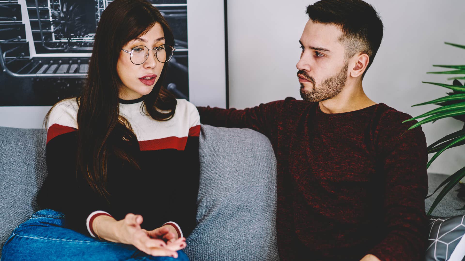 Woman talking next to her boyfriend on the couch.