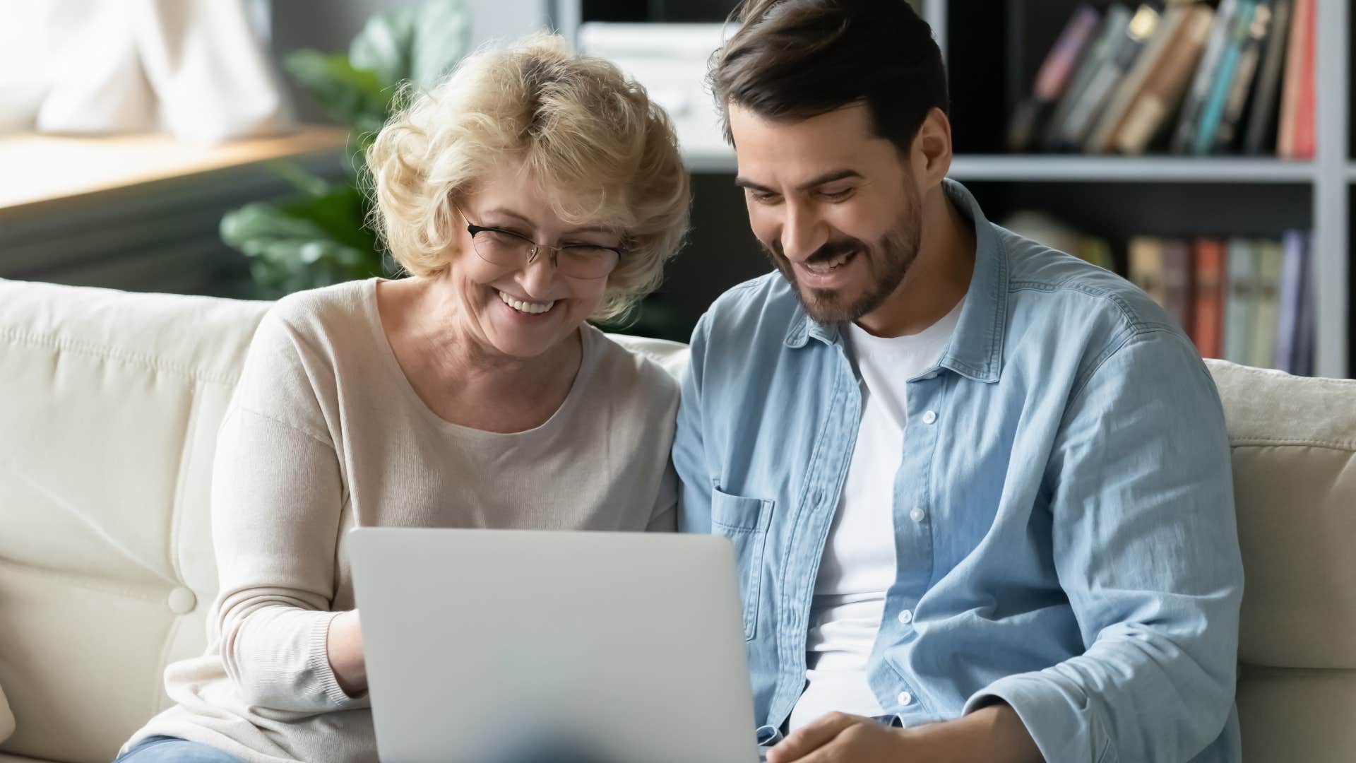 Narcissistic adult man sitting with his mother on a laptop.