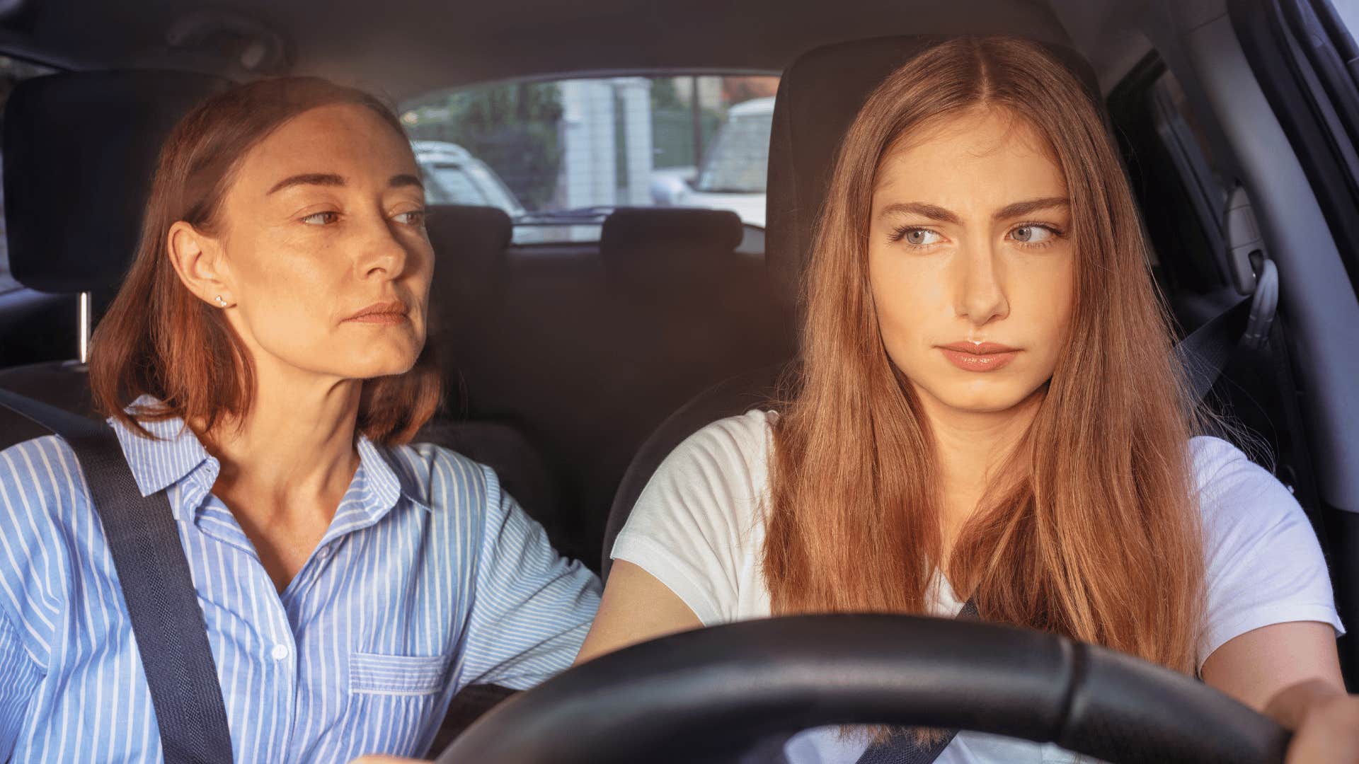 teenage girl driving with her mom