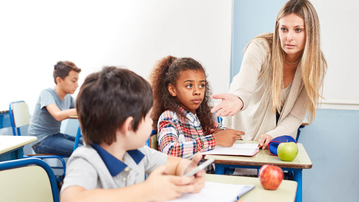 Teacher taking student's phone away in class