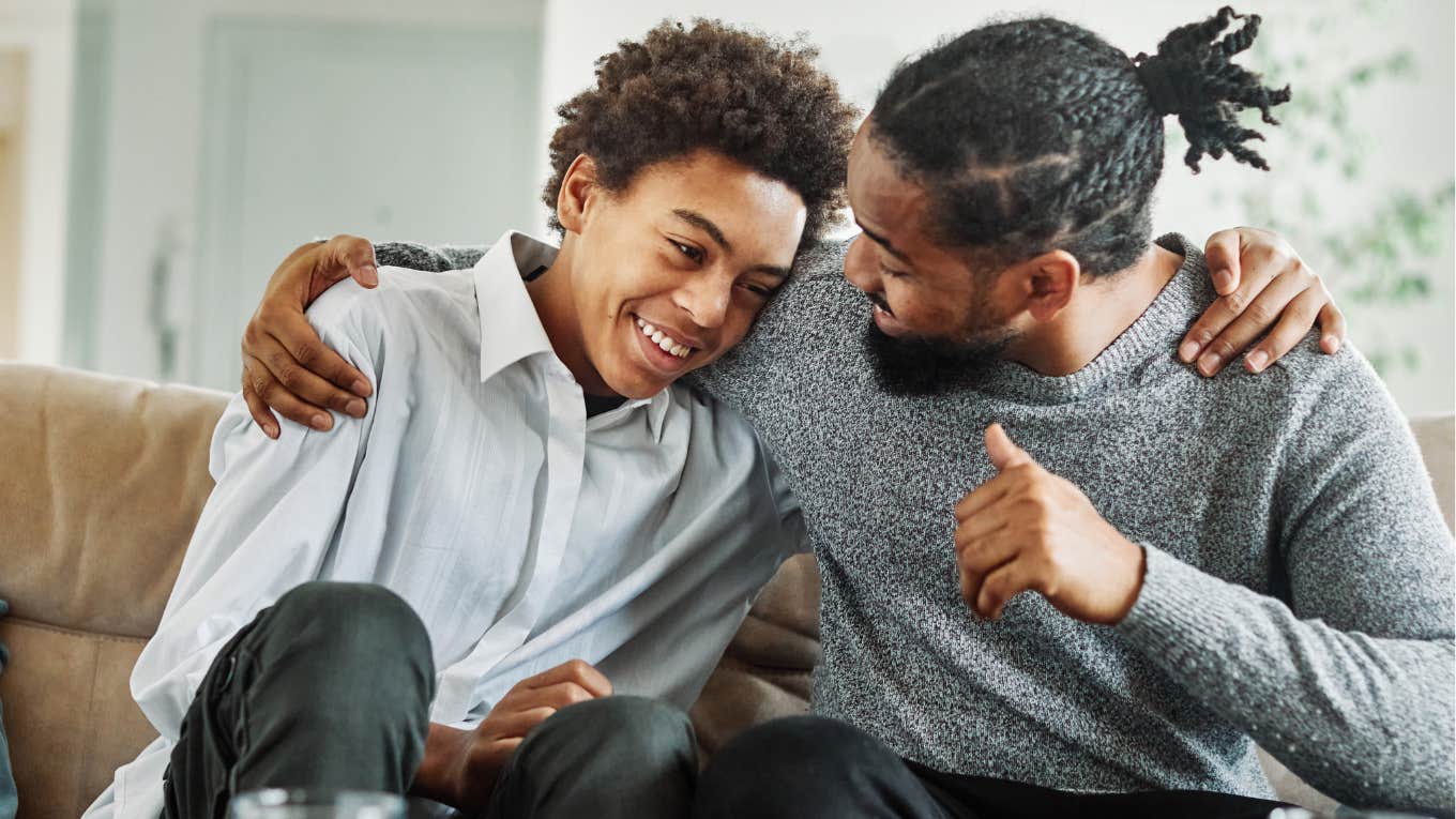 Dad smiling while talking to his teenage son about a legal name change. 