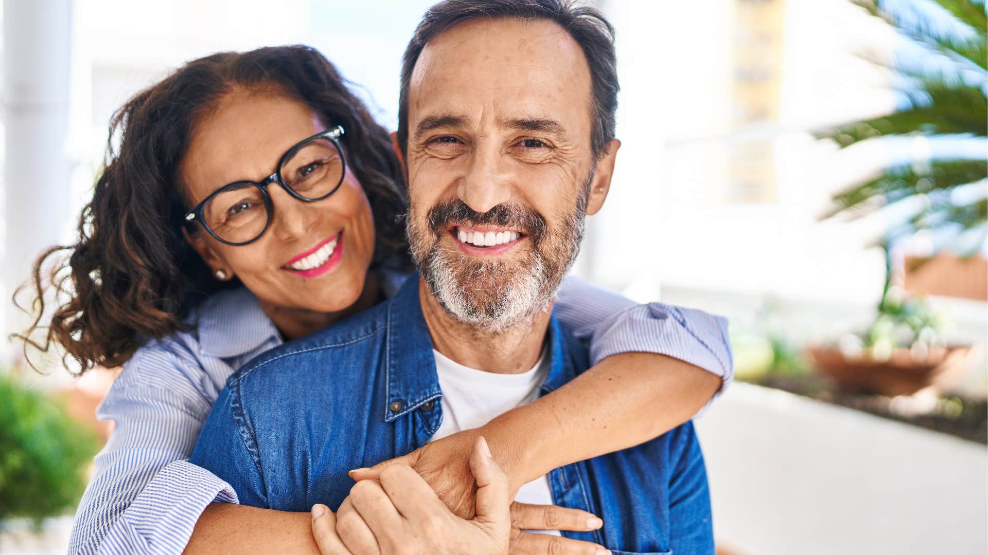 Older couple smiling and hugging at home.