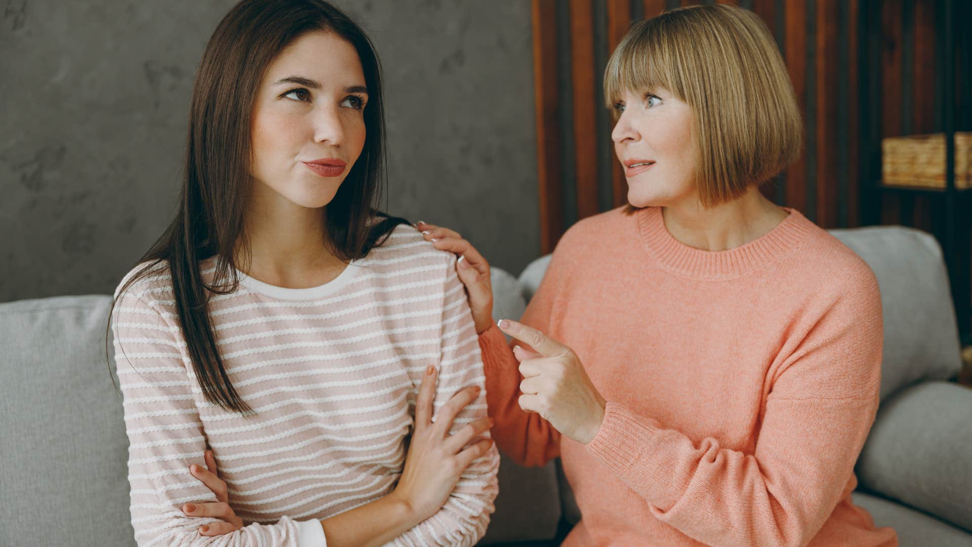 Adult woman sitting with her mom on the couch.