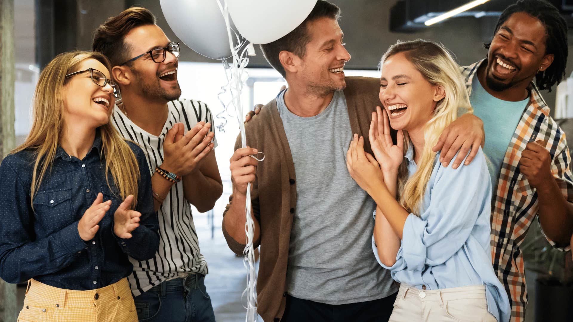 woman smiling as coworkers surprise her 