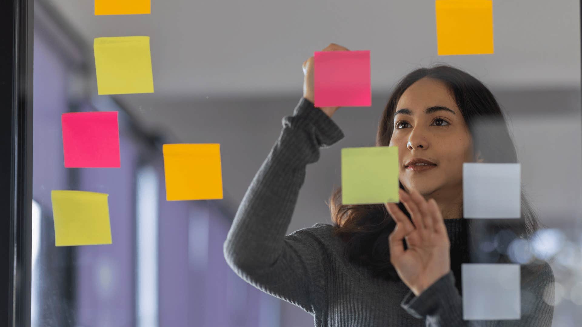 woman writing on sticky notes