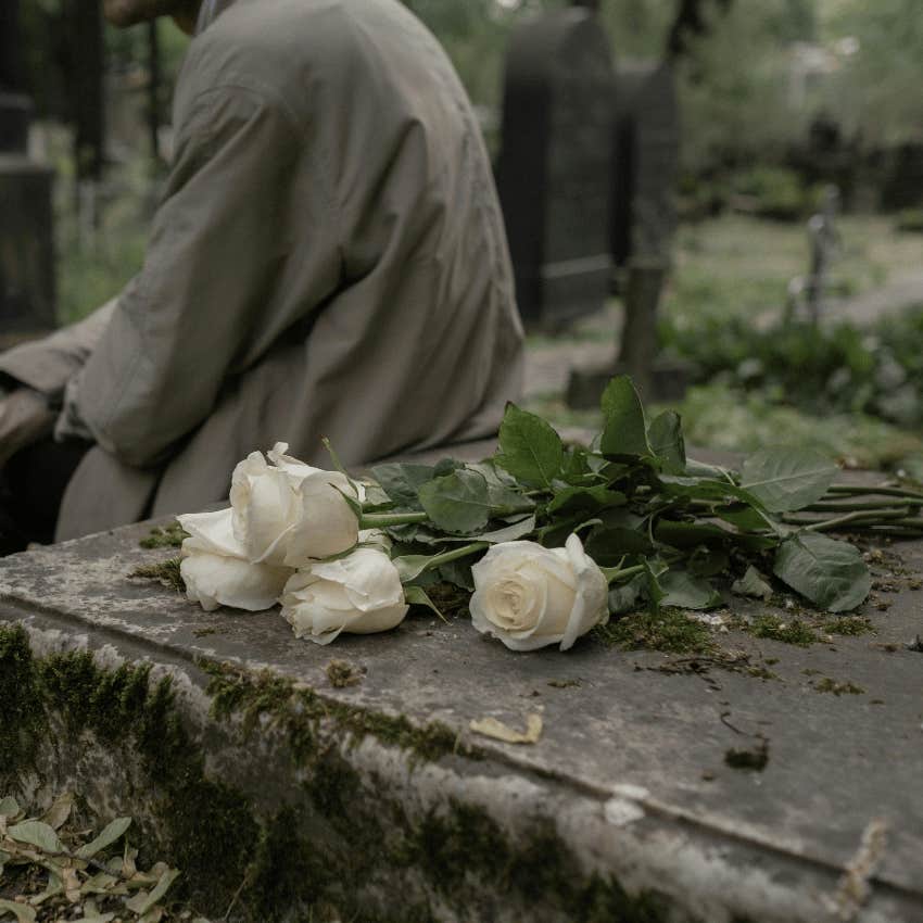 person laying flowers on a grave