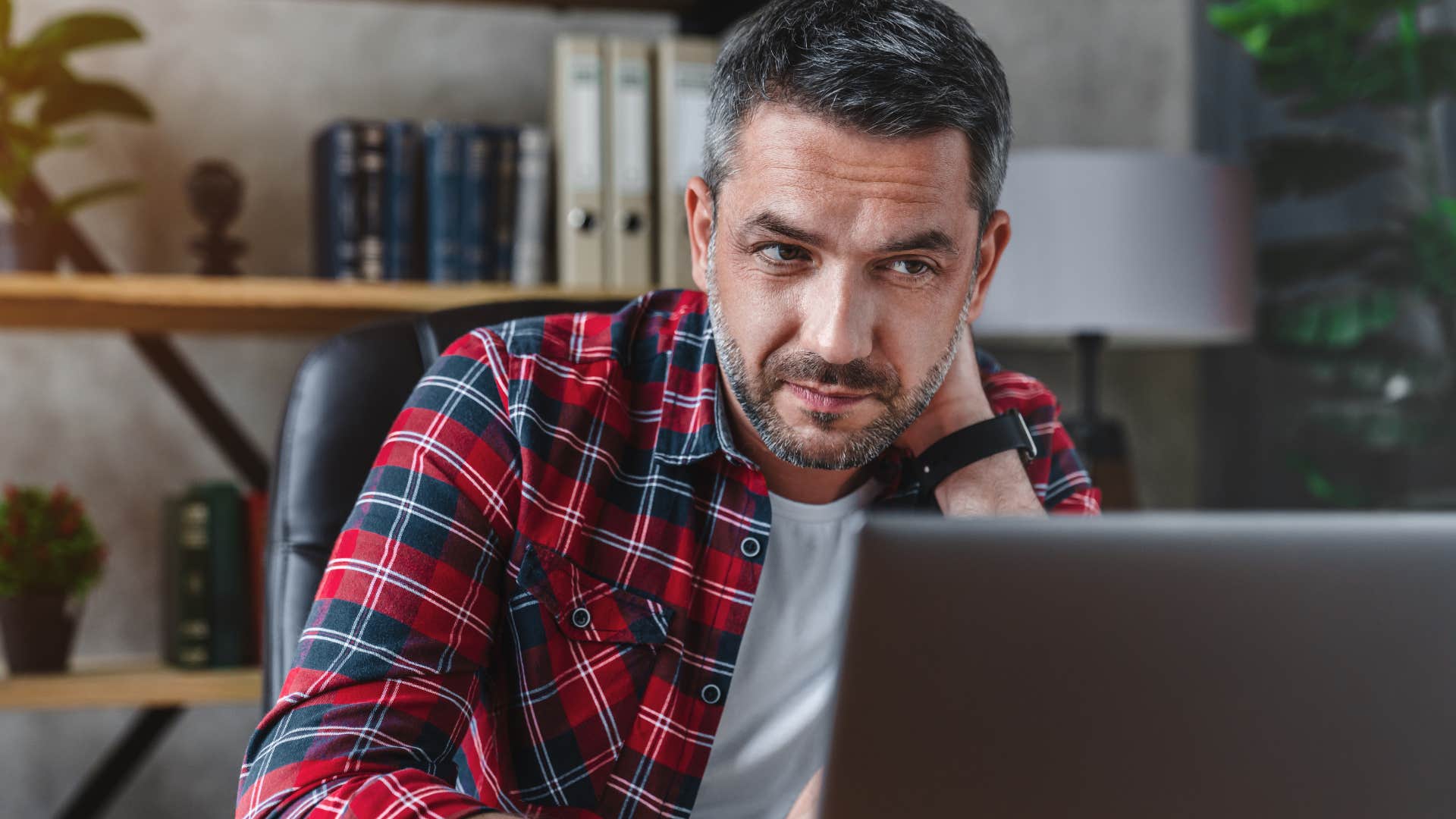 Man looking upset staring at his laptop.