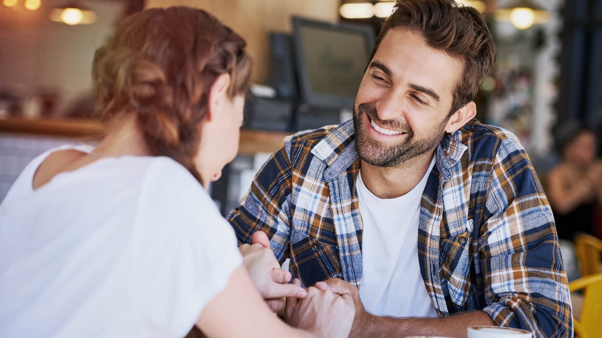 Man smiling and looking at a woman at a table