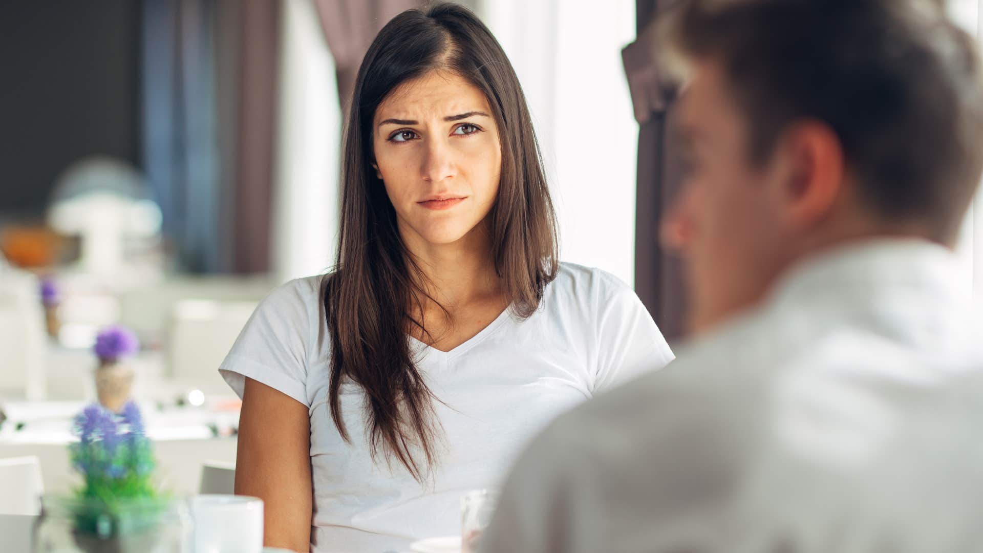 Woman looking confused while a man talks to her