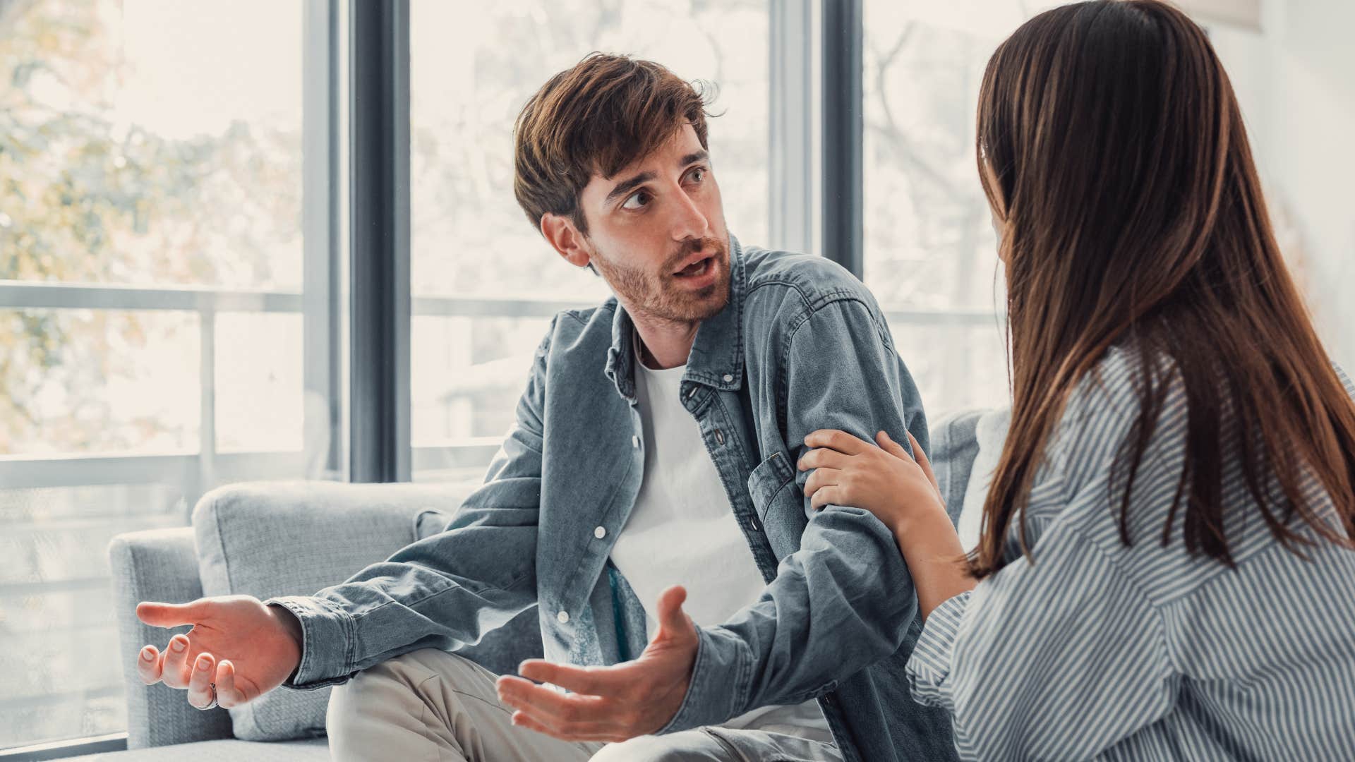 Man looking angry while his girlfriend comforts him