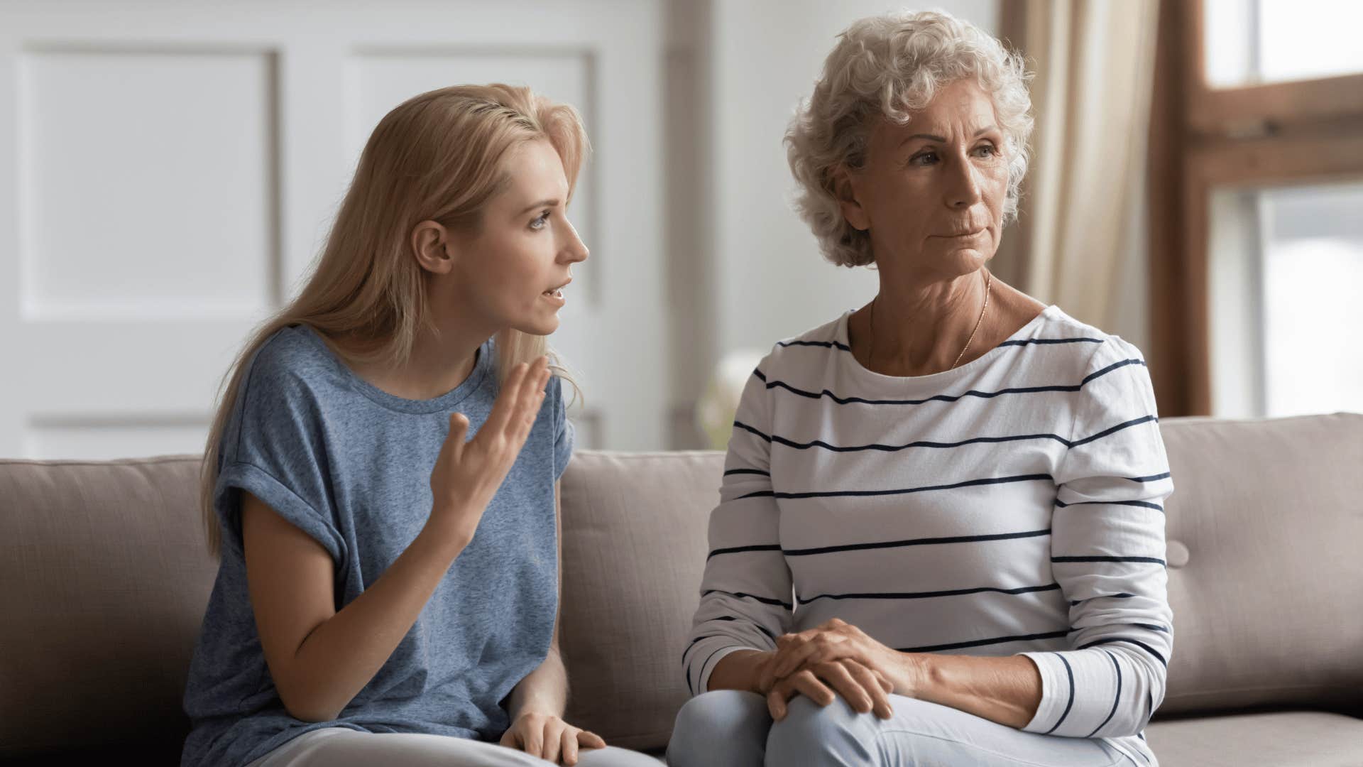 mom and adult daughter sitting on couch