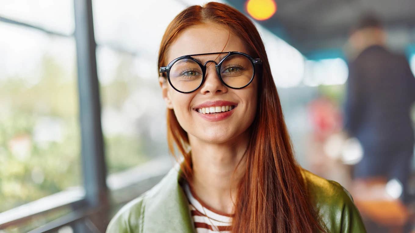 red headed woman with glasses smiling