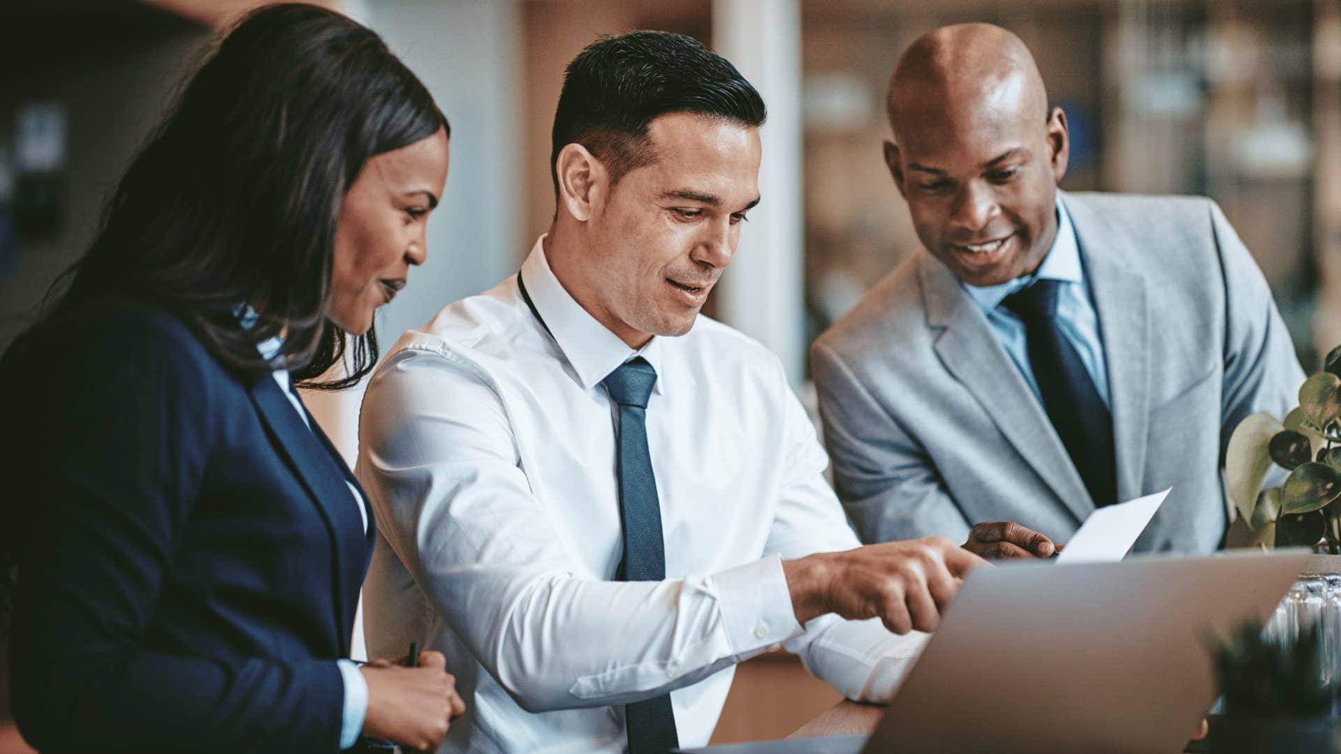 three coworkers looking at laptop