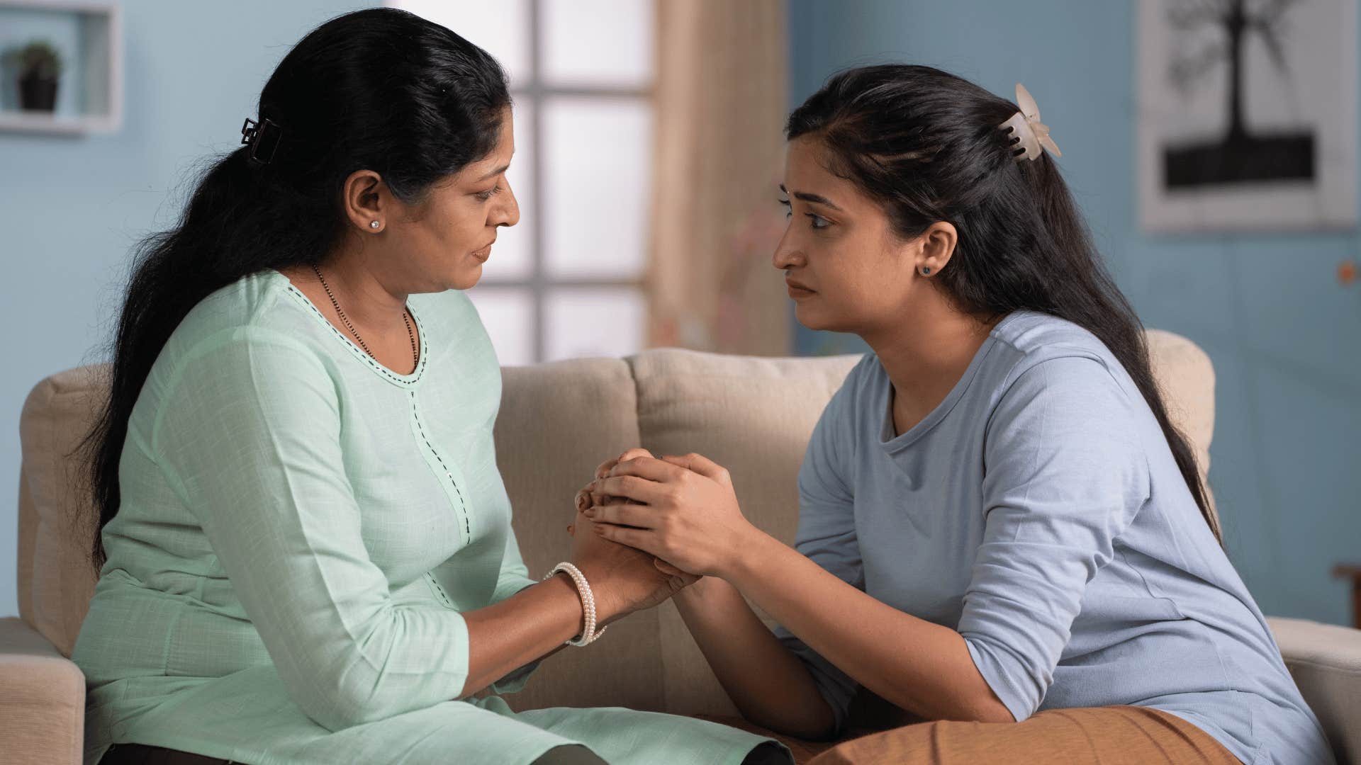 mom and daughter holding hands comforting each other