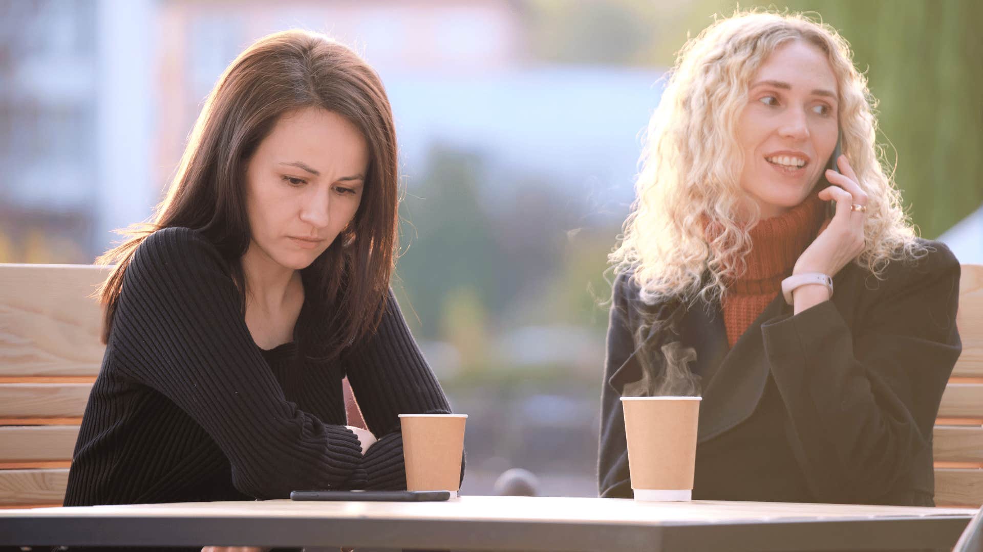 woman being ignored because friend is on phone