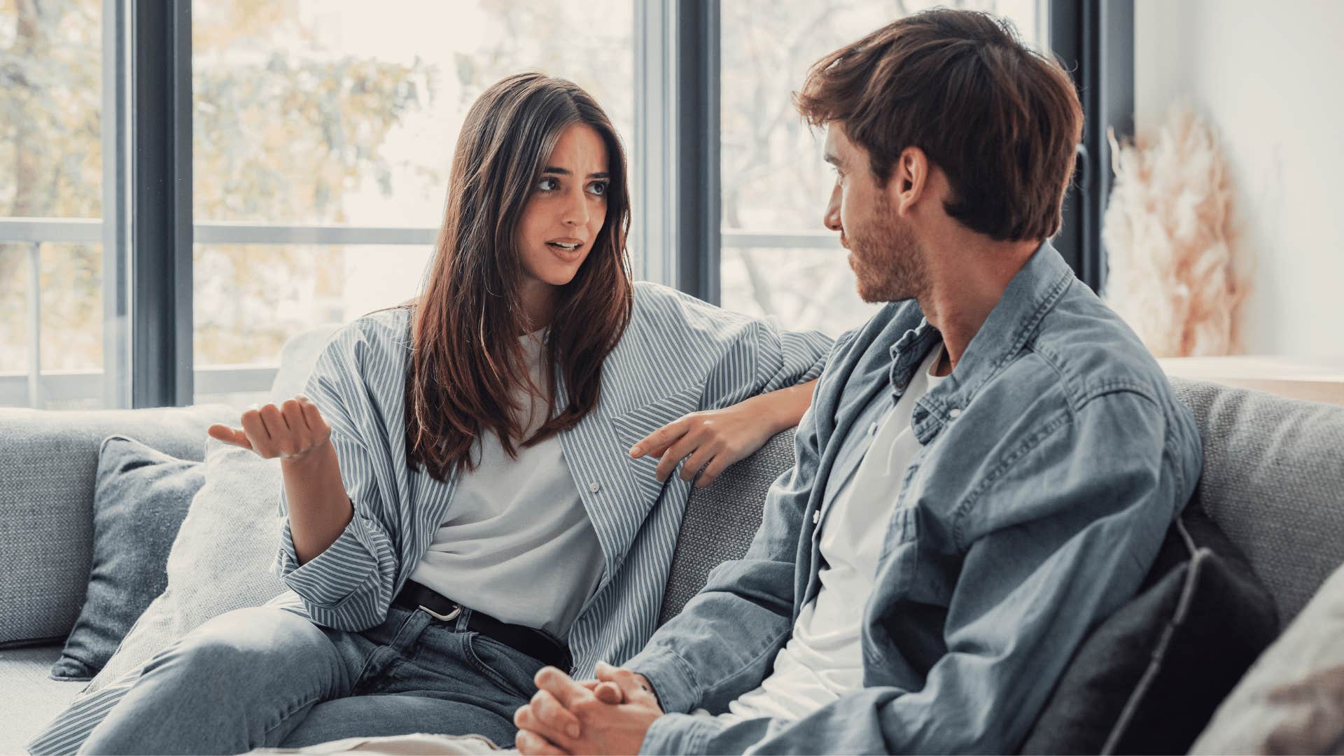 man and woman talking on couch