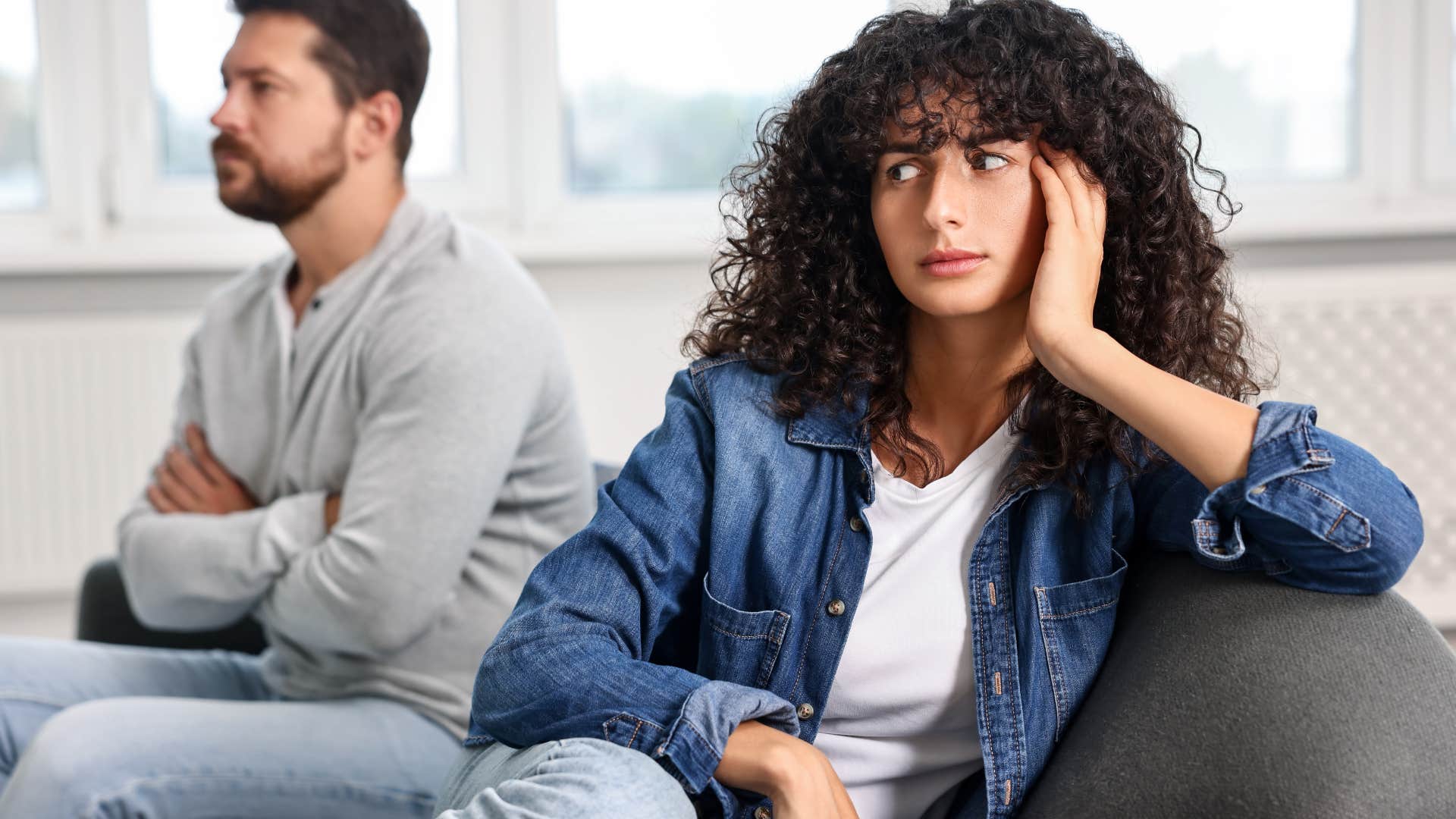 Woman looking frustrated with her back turned to her partner.