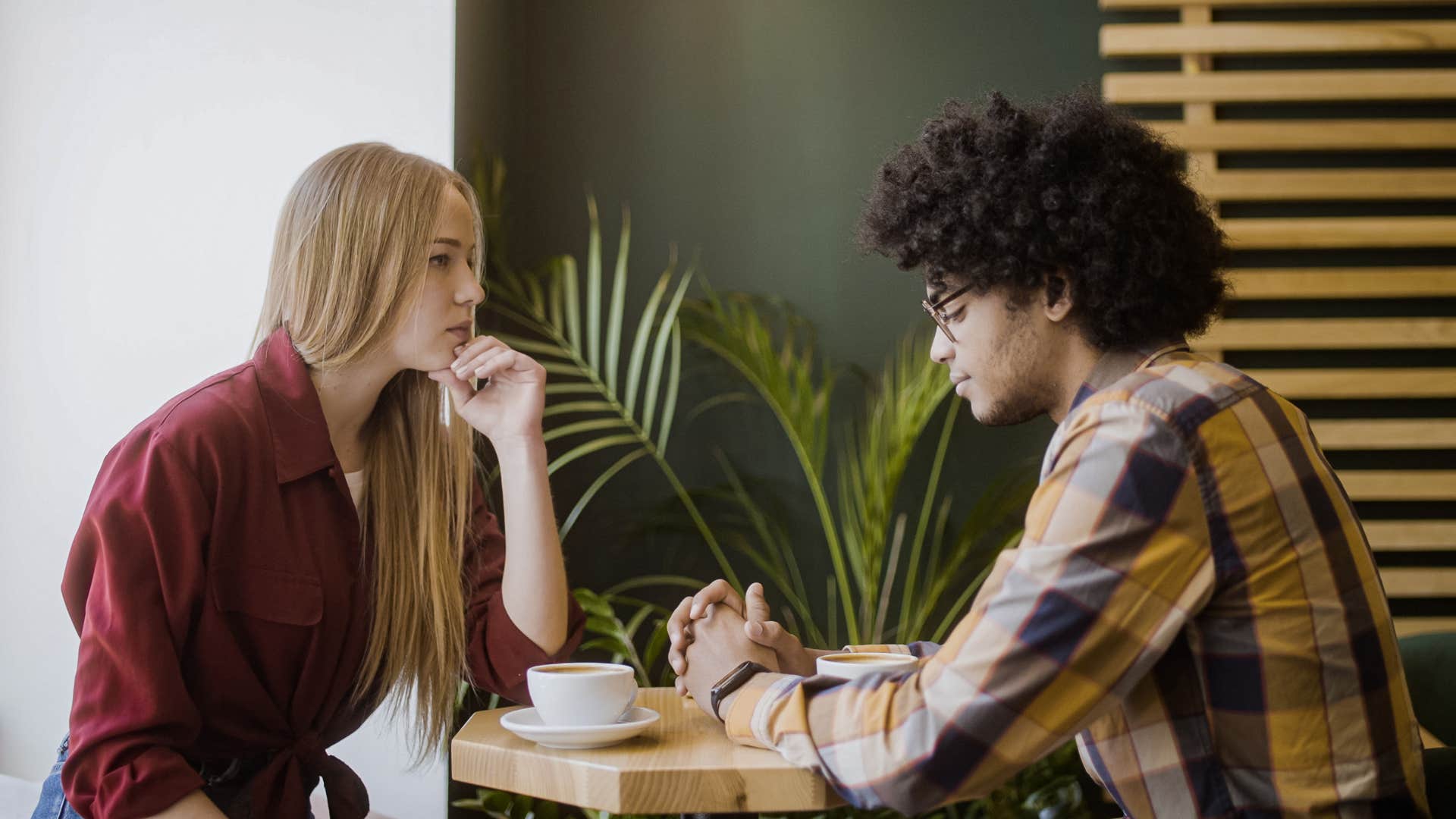 Couple having an intense conversation at a coffee shop table.